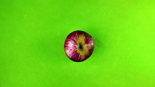 Rotating Apple on Green Background