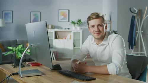 Young Adult Man Sitting at Desk Smiling