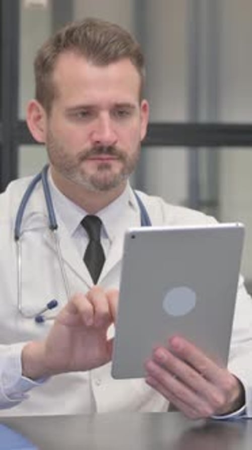 Middle Aged Doctor Using Tablet in Clinic, vertical video