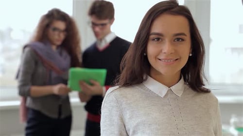 Smiling Young Woman with Team in Background