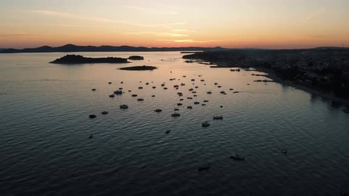 Aerial view on boats shipping in sea, sunset. Sail boats and yachts docked and beautiful golden colo