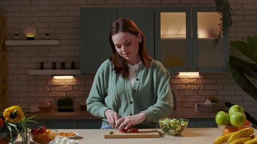 Woman Prepares Healthy Salad in Cozy Kitchen at Night