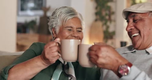 Senior Couple Laughing and Clinking Coffee Mugs