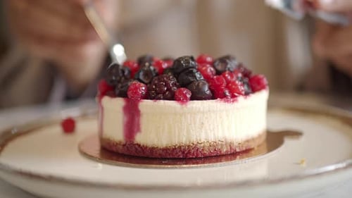 Enjoying Dessert at a Cafe with Berry Cheesecake