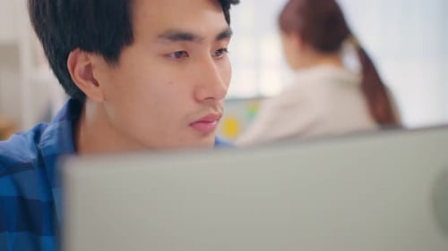 Exhausted Asain business man using laptop computer working in office.
