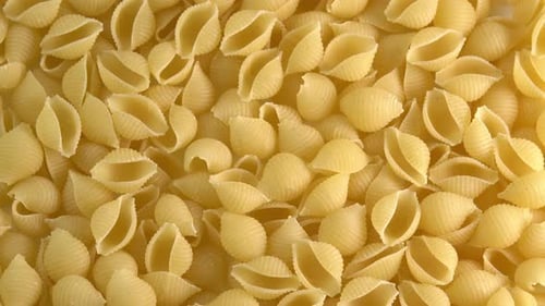 Italian pasta conchiglie rigate shell shaped rotating background closeup top view side light