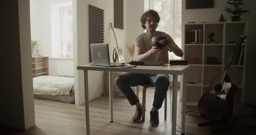 Young Adult Working on Music with Laptop