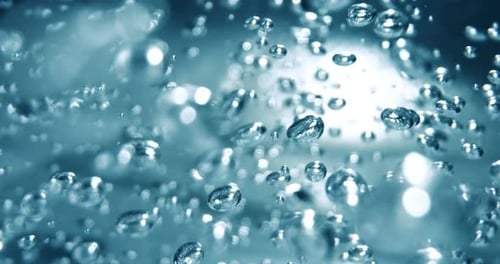 Viele Wasserblasen in blauem Wasser aus nächster Nähe, abstrakte Wasserwelle mit Blasen in Zeitlupe.