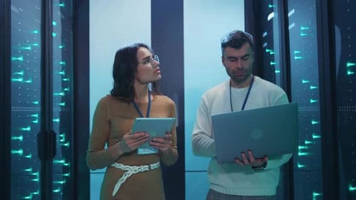 IT Professionals Inspect Data Servers with Laptop and Tablet