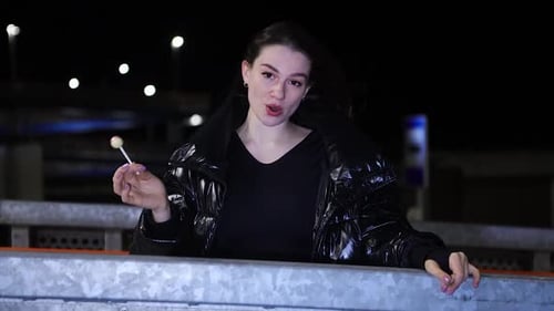 Close up stylish female performer singing in urban area at night