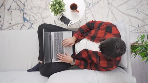 Adult Works on Laptop on Couch Overhead Angle