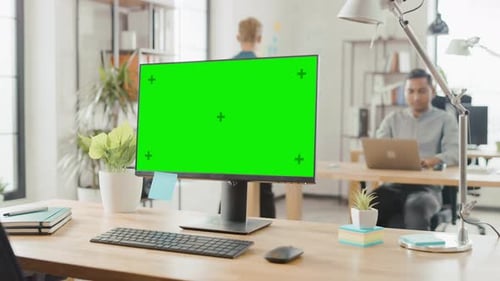 Mock-up Screen Desktop Computer Standing on the Desk in the Modern Creative Office. In the Backgrou