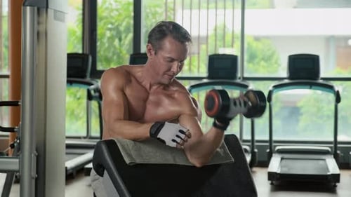 Man Working Out with Dumbbell at the Gym