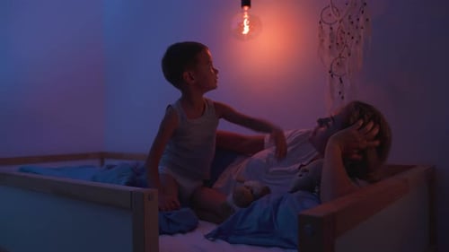 Boy and Mother Cuddling Together in Bedroom