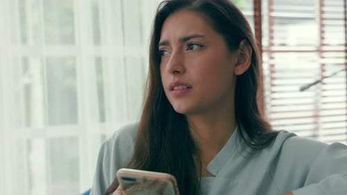 Woman looking frustrated while using her smartphone