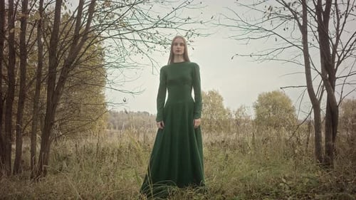 Model posing in green dress in autumn forest
