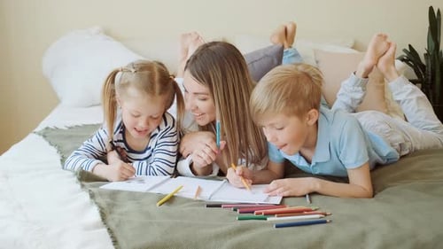 Smiling Woman and Children Drawing on Bed