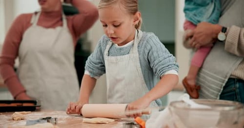 Young Girl Rolling Dough with Family in Kitchen