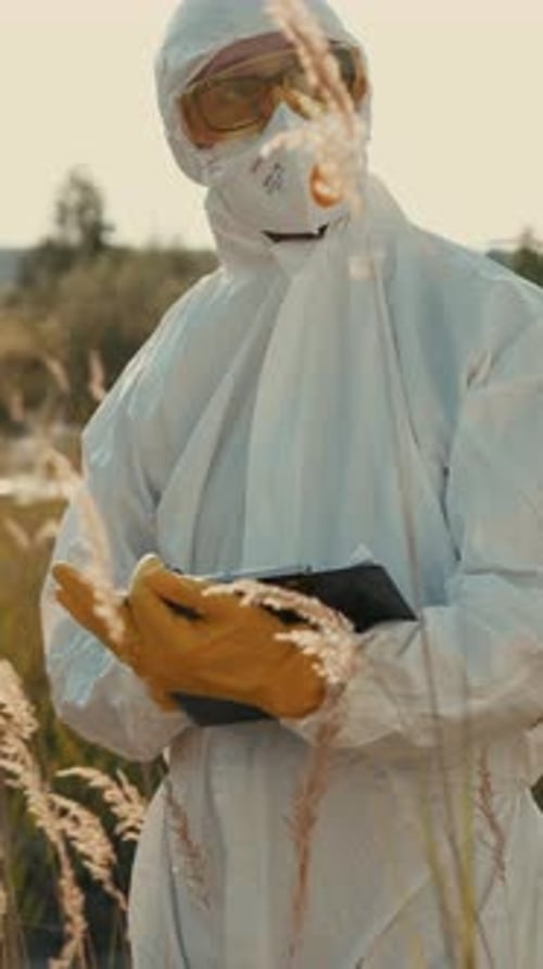 Un científico que lleva equipo de protección está realizando activamente investigaciones y análisis de campo