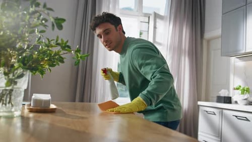 Young Man Cleaning Table in Kitchen