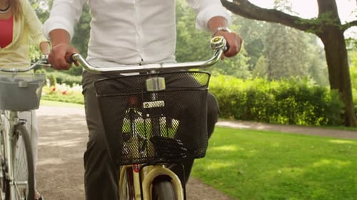 Happy Adult Couple Riding Bicycles in Park.