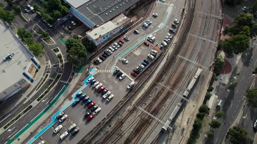 Vista aérea del tren suburbano y los automóviles estacionados en las bahías