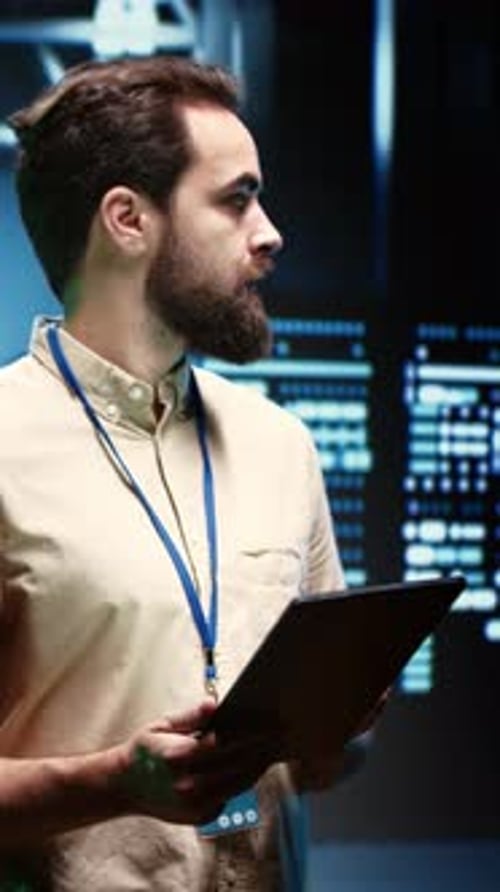 Man Uses Tablet in Futuristic Server Room