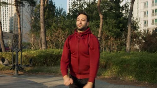 Fit Man in 30s Warming Up Shoulder Joints Orbiting Arms Before Exercises Outdoors at Apartment Park