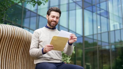 Adult Man Reads Envelope and Cheers in Excitement