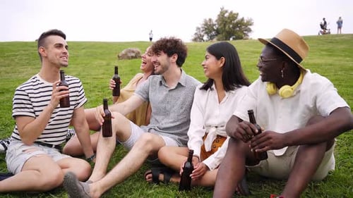 Friends Enjoying a Picnic on Grassy Hill