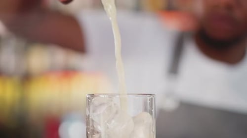 Barman Pours Exotic Cocktail Into Glass in Bar