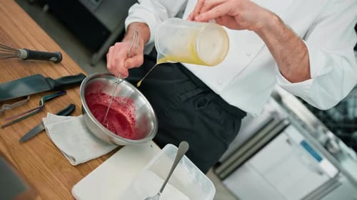 Professional kitchen chef prepares red beetroot sauce for salad mixes ingredients healthy food