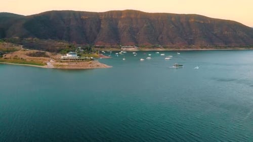 Aerial drone flying over a lake, water dam, with mountains at sunrise. Beautifull dreamy landscape v