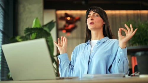 Pretty Young Woman Worker Meditating at Workplace in Office