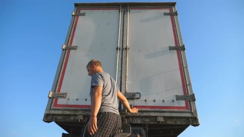 Truck Driver at Back of Big Rig Trailer