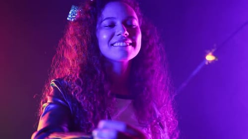 Woman Smiling and Holding Sparkler in the City