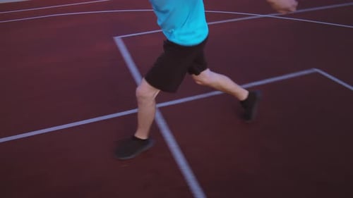 Young Adult Dribbling Basketball on Outdoor Court