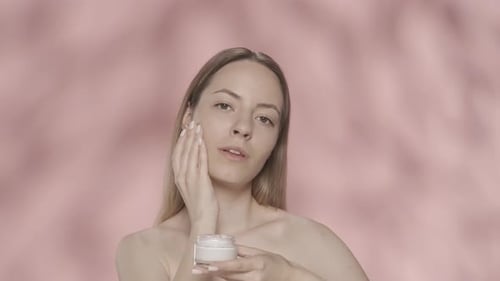 Cream for Skin Care A Young Halfnaked Woman Applies Cream to Her Face Woman with Cream in Her Hands