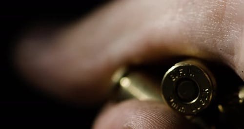 Detailaufnahme einer 919-mm-Parabellum-Kugel, die in der Hand gehalten wird, Rackfokus