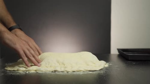 Hands Kneading Fresh Dough on Kitchen Table