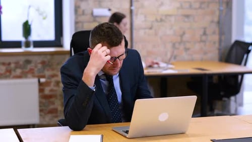 Realtime Video Caucasian Man is Sitting and Looking at His Computer in Office with Bricks Walls Male