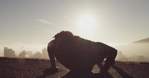 Young Adult Silhouette Doing Pushups at Sunrise