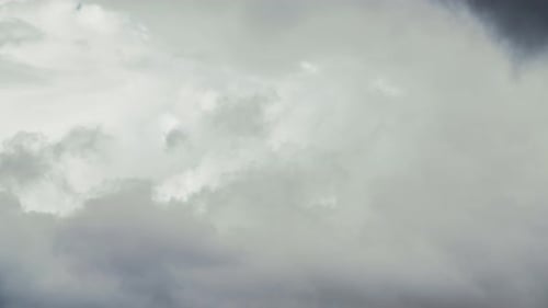 Diversas capas de nubes blancas que cambian dinámicamente sobre la ciudad.