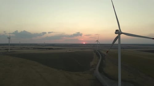 Windmills Generating Electric Power in a Serene Park at Sunset Showcasing Green Energy and