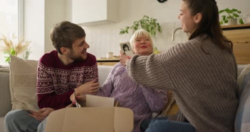 Three Family Members Enjoying Photos on Sofa