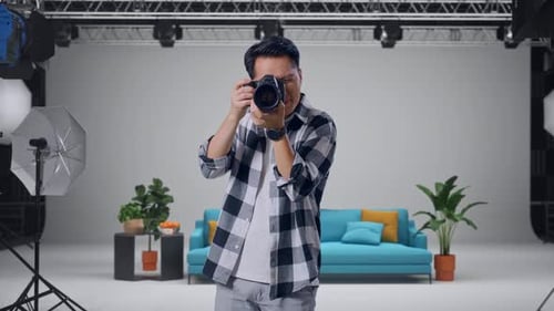 Asian Photographer Using A Camera Taking Picture In The Studio