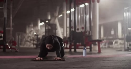 Muslim Sportswoman Stretching Back in Gym