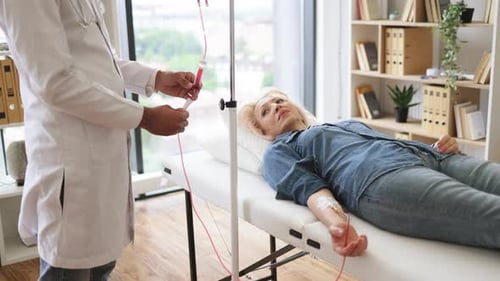 Cropped View of Caucasian Senior Woman Making Blood Transfusions