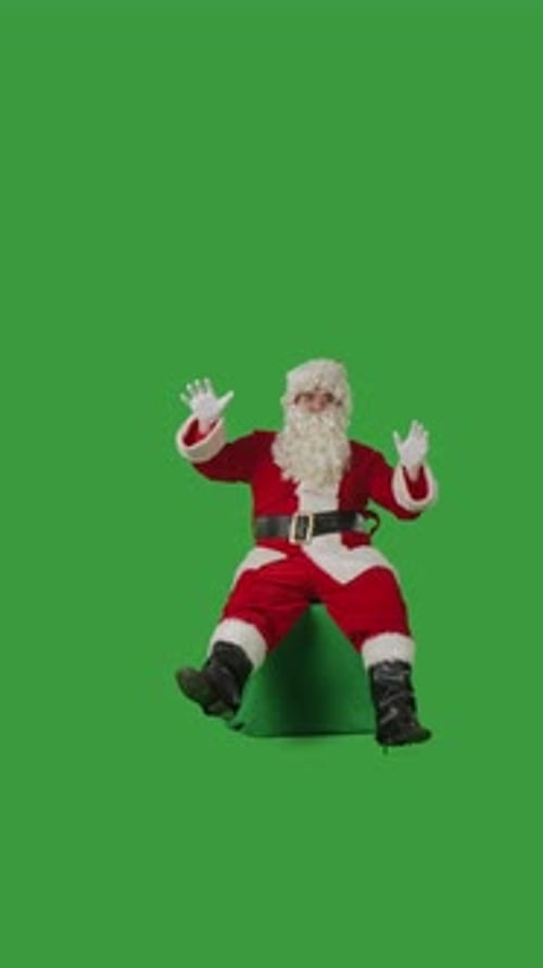 Santa Claus Dancing While Sitting on a Green Mockup Against a Green Chroma Key Background