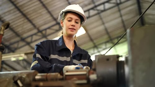 Trabalhadora de fábrica está montando uma máquina de torno CNC na oficina.